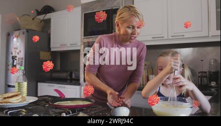 Image de fleurs sur une mère caucasienne heureuse et sa fille cuisinant ensemble Banque D'Images