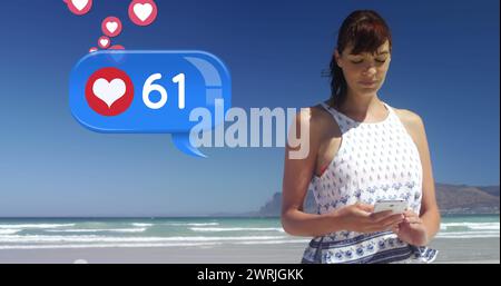 Gros plan d'une femme caucasienne qui envoie des SMS sur la plage par une journée ensoleillée Banque D'Images