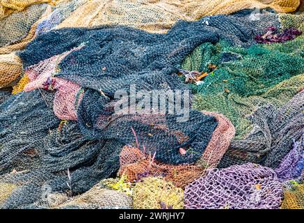 Filets de pêche colorés abandonnés sur un cimetière de bateaux Banque D'Images