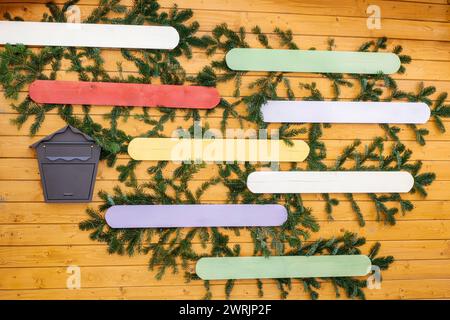 Panneau de plaques vides pour les messages sur le mur d'une maison de Noël en bois avec des branches de sapin et une boîte aux lettres Banque D'Images