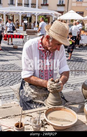 Sibiu City, Roumanie - 03 septembre 2023. Un potier plus âgé façonnant un pot en argile sur une roue de poterie à la foire des potiers de Sibiu, Roumanie Banque D'Images