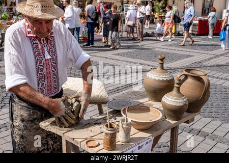 Sibiu City, Roumanie - 03 septembre 2023. Un potier plus âgé façonnant un pot en argile sur une roue de poterie à la foire des potiers de Sibiu, Roumanie Banque D'Images