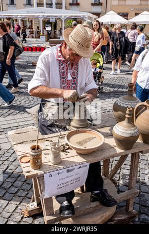 Sibiu City, Roumanie - 03 septembre 2023. Un potier plus âgé façonnant un pot en argile sur une roue de poterie à la foire des potiers de Sibiu, Roumanie Banque D'Images