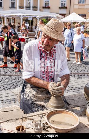 Sibiu City, Roumanie - 03 septembre 2023. Un potier plus âgé façonnant un pot en argile sur une roue de poterie à la foire des potiers de Sibiu, Roumanie Banque D'Images