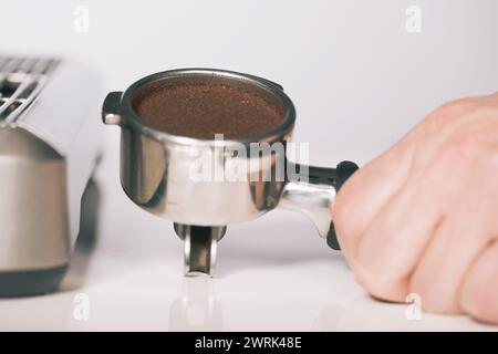 Presser le café moulu dans la poignée pour l'extraire dans la machine à espresso Banque D'Images