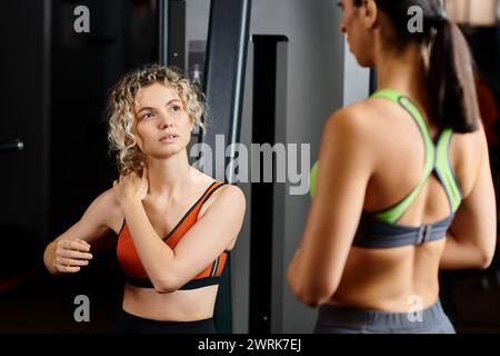 belle entraîneur féminin expliquant à son client jolly attrayant comment utiliser la machine de presse de poitrine Banque D'Images