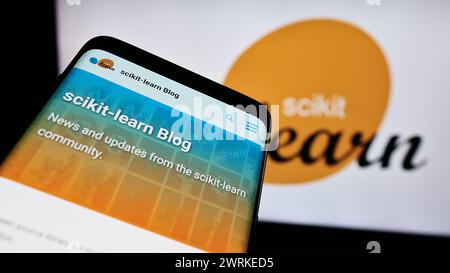 Smartphone avec site Web de la bibliothèque de machine learning logiciel scikit-learn devant le logo. Concentrez-vous sur le coin supérieur gauche de l'écran du téléphone. Banque D'Images