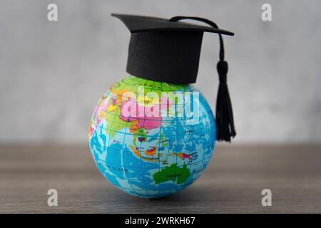Chapeau de graduation sur le dessus du globe terrestre avec espace de copie. Étudiez à l'étranger. concept d'étudiants étrangers. Banque D'Images