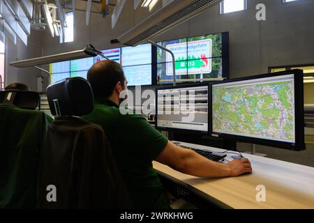 Hoyerswerda, Allemagne. 13 mars 2024. Les employés sont assis devant des écrans d'ordinateur dans la salle de surveillance du centre de contrôle de la caserne de pompiers principale dans le cadre d'un événement de presse intitulé « 20 ans du système automatique d'alerte précoce aux incendies de forêt » (AWFS). Le centre de contrôle est responsable de la surveillance conjointe avec les pompiers pour les districts de Görlitz, Bautzen, Meißen et Saxe du Nord. Crédit : Robert Michael/dpa/Alamy Live News Banque D'Images