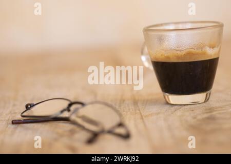 café expresso dans une tasse en verre avec les verres au premier plan Banque D'Images