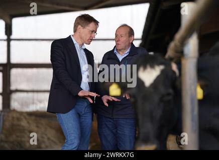 13 mars 2024, Schleswig-Holstein, Mörel : Daniel Günther (à gauche, CDU), ministre-président du Schleswig-Holstein, et Klaus-Peter Lucht, président de l'Association des agriculteurs du Schleswig-Holstein, se tiennent dans l'étable de la ferme de Lucht. Le ministre-président Günther a visité la ferme du président des agriculteurs du Schleswig-Holstein, Lucht, pour discuter de la situation actuelle dans le secteur agricole. Photo : Marcus Brandt/dpa Banque D'Images