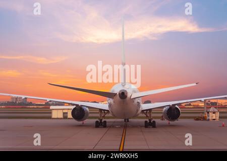 Avion de passagers garé dans le port aérien pendant le ciel de l'aube, vue arrière. Banque D'Images