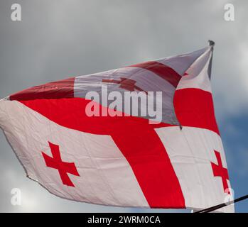 Georgia drapeau national tissu de tissu ordonnant sur le ciel avec belle lumière du soleil - image. Banque D'Images