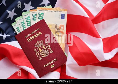 Passeport espagnol rouge de l'Union européenne et de l'argent sur le fond du drapeau national des États-Unis en gros plan. Tourisme et concept de diplomatie Banque D'Images