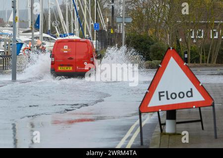 Weymouth, Dorset, Royaume-Uni. 13 mars 2024. Météo britannique : un van traverse les eaux de crue d'une marée printanière élevée sur commercial Road à côté du port de Weymouth dans le Dorset par un matin chaud couvert. Crédit photo : Graham Hunt/Alamy Live News Banque D'Images