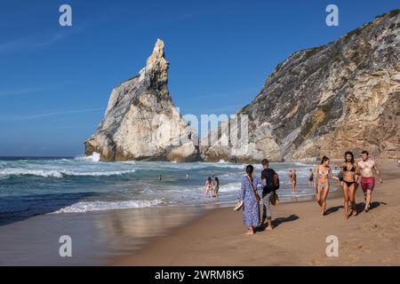 Les gens à la plage de Praia da Ursa au Portugal, rivage sablonneux isolé par l'océan Atlantique avec des formations rocheuses pittoresques dans l'ouest de l'Europe continentale. Banque D'Images