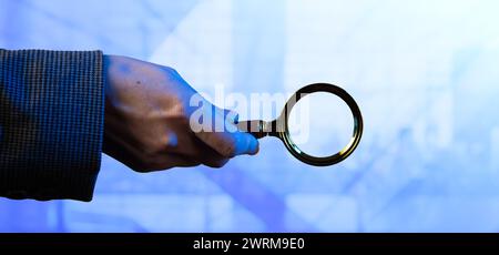 Collage Tech CG. Une main féminine tient une loupe sur un fond technologique léger. Banque D'Images