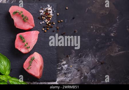 filets de thon frais crus sur fond noir Banque D'Images