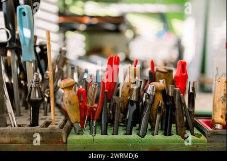 Une collection d'outils de cordonnerie bien utilisés sur un poste de travail dans un magasin autrichien, illustrant l'artisanat du cordonnier. Banque D'Images