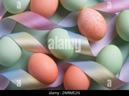 Vue de dessus des œufs de Pâques de couleur pastel nichés entre des rubans soyeux, une célébration invitante des vacances de Pâques. Banque D'Images