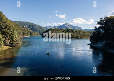 Vue aérienne des kayakistes qui pagayent sur un lac tranquille entouré de forêts luxuriantes et de montagnes dans la nature sauvage préservée de Patagonie Banque D'Images