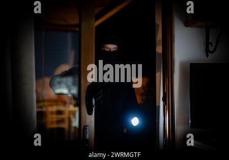 Le voleur se brise dans la maison par le balcon. Banque D'Images