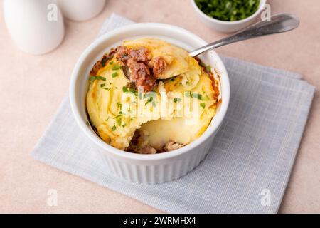 Tarte au berger dans un plat blanc à portions. Cocotte traditionnelle maison (gratin) avec viande hachée et purée de pommes de terre. Mise au point sélective, proche Banque D'Images