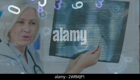Image des nombres changeant et des oscilloscopes sur les écrans au-dessus d'un médecin féminin avec radiographie Banque D'Images