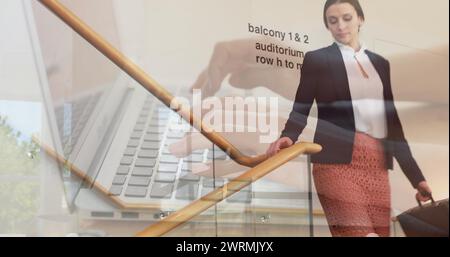 Image de mains à l'aide d'un ordinateur portable, au-dessus d'une femme d'affaires marchant dans l'escalier au lieu de travail Banque D'Images