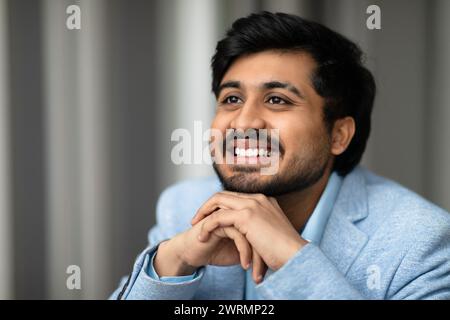 Portrait d'homme d'affaires moyen-oriental souriant réussi regardant de côté à l'intérieur Banque D'Images