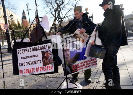 Moscou, Russie. 13 mars 2024. Un militant pro-Poutine porte une affiche de campagne près du Kremlin de Moscou, le 13 mars 2024. L'élection présidentielle russe se déroulera sur une période de trois jours, du 15 au 17 mars. Photo de Yuri Gripas/ABACAPRESS.COM crédit : Abaca Press/Alamy Live News Banque D'Images