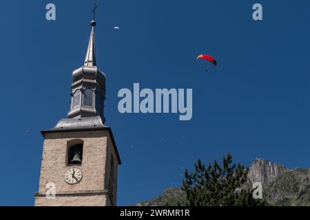 Parapente survolant le clocher de l'église Saint Michel avec le pic du Brévent en arrière-plan en été, Chamonix, haute Savoie, France Banque D'Images