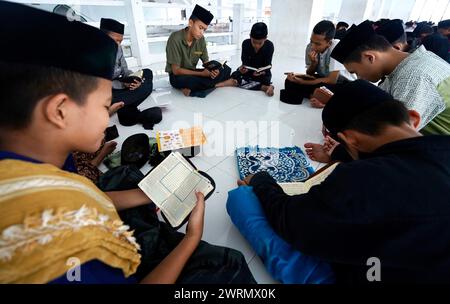 Medan, Indonésie. 13 mars 2024. Des étudiants musulmans de Ar-Raudlatul Hasanah récitent le Coran le deuxième jour du Ramadan à Medan, dans le Nord de Sumatra, Indonésie, le 13 mars 2024. Les musulmans du monde entier marquent le mois du Ramadan, le mois le plus Saint du calendrier islamique au cours duquel les dévots jeûnent de l'aube au crépuscule. (Photo Hendro Budiman/INA photo Agency /Sipa USA) crédit : Sipa USA/Alamy Live News Banque D'Images