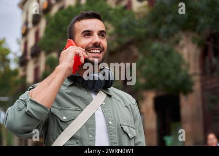 Bel homme utilisant le téléphone pour appeler des amis, parler et avoir une belle conversation par téléphone. Banque D'Images