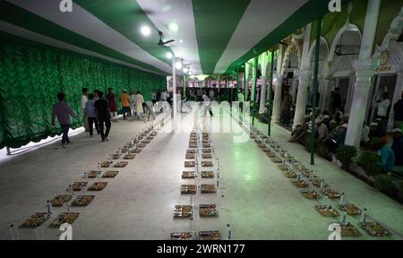 Des bénévoles distribuent et organisent des rangées de repas 'iftar' pour les dévots afin de rompre leur jeûne, pendant le mois sacré du Ramadan, à Burha Jame Masjid, le 13 mars 2024 à Guwahati, Assam, Inde. Crédit : David Talukdar/Alamy Live News Banque D'Images