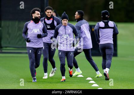 Anfield, Liverpool, Royaume-Uni. 13 mars 2024. Conférence de presse de Liverpool et entraînement avant le match de l'UEFA Europa League contre le Sparta Prague à Liverpool, en Angleterre. Mohamed Salah montre la voie aux côtés de Kostas Tsimikas et Jarell Quansah lors de la séance d'entraînement d'aujourd'hui au centre d'entraînement AXA de Liverpool à Kirkby, avant le match de demain du Groupe Europa League des 16 contre Sparta Prague Credit : action plus Sports/Alamy Live News Banque D'Images