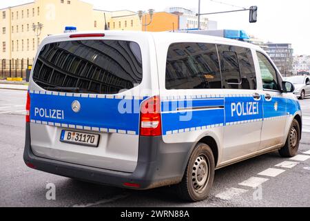 Autobus de police blanc et bleu garé dans la rue à Berlin, symbole loi et ordre, réponse d'urgence, coopération internationale dans le maintien de la secu nationale Banque D'Images