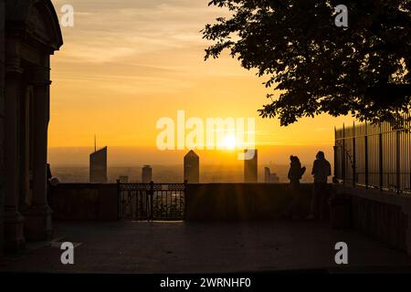 Silhouettes de personnes contemplant le lever de soleil sur les tours du quartier d’affaire de la part-Dieu à Lyon depuis Fourvière Banque D'Images