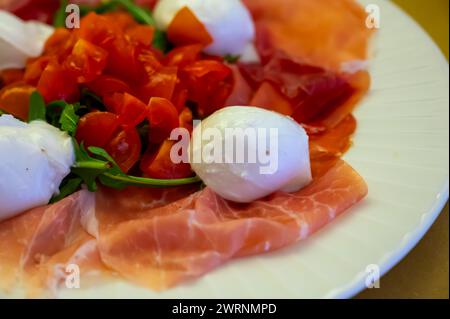 Cuisine de la région Emilie-Romagne, salade Caprese avec Prosciutto crudo, prosciutto di Parma, mozzarella et tomates, déjeuner à Parme, Italie Banque D'Images