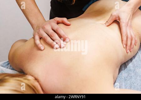 Profitez d'un massage du dos agréable avec un masseur expérimenté dans une ambiance de spa sereine. Banque D'Images