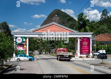 La porte impériale de la ville Petropolis sur l'avenue Ayrton Senna tandis que la circulation passe sous elle sous l'après-midi d'été ensoleillé ciel bleu nuageux. Banque D'Images