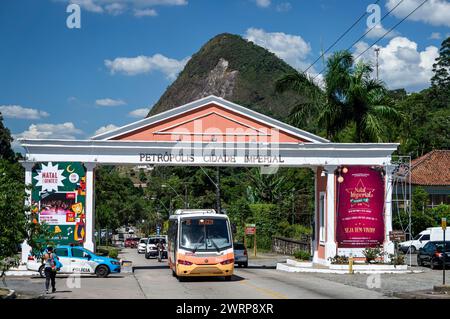 La porte impériale de la ville Petropolis sur l'avenue Ayrton Senna tandis que la circulation passe sous elle sous l'après-midi d'été ensoleillé ciel bleu nuageux. Banque D'Images