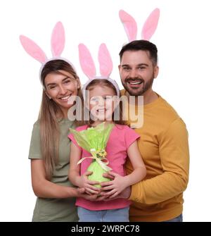 Fête de Pâques. Famille heureuse avec des oreilles de lapin et oeuf enveloppé isolé sur blanc Banque D'Images