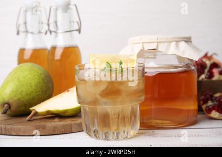 Savoureux kombucha et glaçons en verre sur une table en bois blanc, gros plan Banque D'Images