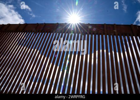 Campo, États-Unis. 13 mars 2024. Le soleil brille à travers le mur frontalier séparant les États-Unis et le Mexique (arrière) près de Campo, Californie, à environ 50 miles de San Diego, le mercredi 13 mars 2024. Un projet de loi bipartisan sur l'immigration sénatoriale visant à régler la question de l'immigration migrante est bloqué à la Chambre en raison de la politique de l'année électorale. Photo de Pat Benic/UPI crédit : UPI/Alamy Live News Banque D'Images