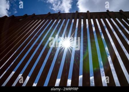 Campo, États-Unis. 13 mars 2024. Le soleil brille à travers le mur frontalier séparant les États-Unis et le Mexique (arrière) près de Campo, Californie, à environ 50 miles de San Diego, le mercredi 13 mars 2024. Un projet de loi bipartisan sur l'immigration sénatoriale visant à régler la question de l'immigration migrante est bloqué à la Chambre en raison de la politique de l'année électorale. Photo de Pat Benic/UPI crédit : UPI/Alamy Live News Banque D'Images