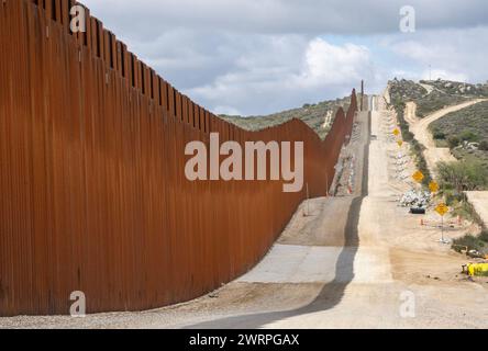 Campo, États-Unis. 13 mars 2024. Le mur frontalier séparant les États-Unis et le Mexique (l) est vu près de Campo, Californie, à environ 50 miles de San Diego, le mercredi 13 mars 2024. Un projet de loi bipartisan sur l'immigration sénatoriale visant à régler la question de l'immigration migrante est bloqué à la Chambre en raison de la politique de l'année électorale. Photo de Pat Benic/UPI crédit : UPI/Alamy Live News Banque D'Images