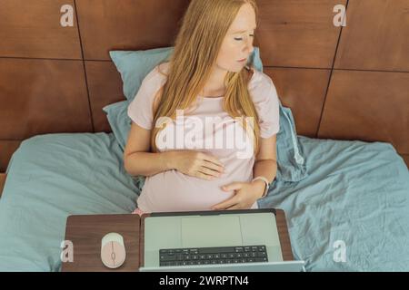 Une femme enceinte fatiguée, fatiguée de travailler à domicile, relève les défis de l'équilibre entre les tâches professionnelles et les exigences de la grossesse Banque D'Images