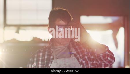 Image de lumière incandescente au-dessus de l'homme caucasien dans l'atelier Banque D'Images