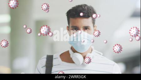 Image de cellules virales au-dessus d'un homme latin portant un masque facial Banque D'Images